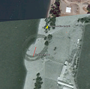 Fig. 3 Overaly of original 1974 photo of the dredging operation on Google Earth. The hump in the beach line is where the dredge pipe unloaded sand onto the beach. The red line is a 50 yard scale bar to show the extent the sand was pushed aside. The yellow marker is the recovered money find 150 yards away.