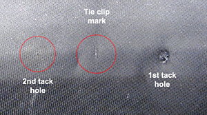 Fig. 3 Tie tack holes found on Coopers tie. Note permanent depression surrounding hole on right.