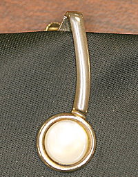 Fig. 1  Close-up of tie clip from black tie found on Cooper's seat.